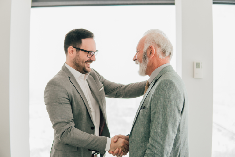 Hotel Management Consultancy Services | Mims Consulting Group Business professionals shaking hands, symbolizing successful partnerships and growth through Mims Consulting Group’s hotel management consultancy services for key benefits of investing in a hospitality management solution.